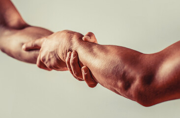 People shaking hands on grey background. Rescue, helping gesture or hands. Concept of salvation....