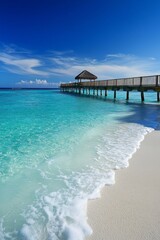 Fototapeta premium A beautiful beach with a pier, crystal clear water, blue sky 