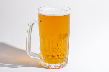 A cold glass of light beer on a white background, perfect for Oktoberfest celebrations and summer refreshment concepts