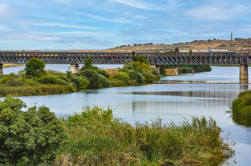 Fototapeta premium The Iron Railway Bridge over the Guadiana river (inaugurated in 1883), the maximum exponent of this type of architecture in Merida, Badajoz, Extremadura, Spain