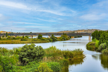 Fototapeta premium The Iron Railway Bridge over the Guadiana river (inaugurated in 1883), the maximum exponent of this type of architecture in Merida, Badajoz, Extremadura, Spain