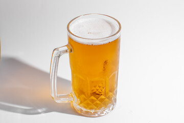A foamy, golden beer in a glass mug, perfect for celebrating Oktoberfest or enjoying a refreshing drink