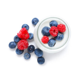 Jar of tasty yogurt with fresh blueberries and raspberries on white background