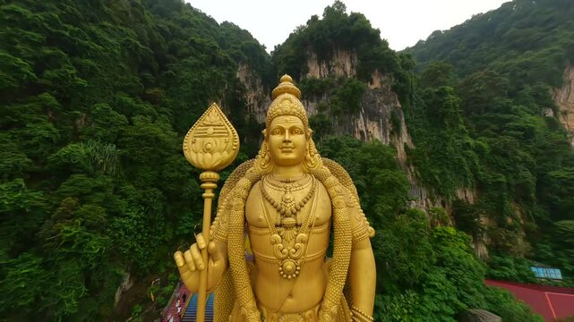 Cinematic FPV shot of Batu Caves and gold statue of Murugan in Kuala Lumpur, Malaysia