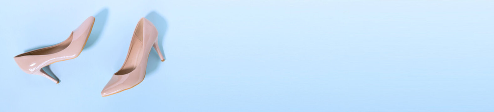 Classic beige women's shoes with medium heels on a blue background. The concept of sales and advertising. flatly. From above. Banner. Copy space