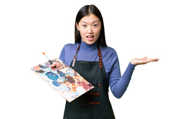 Young artist woman holding a palette over isolated chroma key background with shocked facial expression