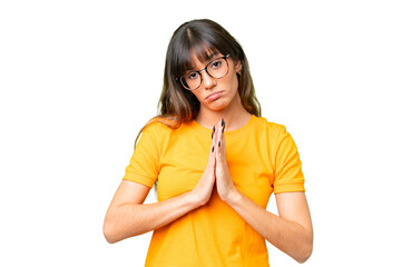 Young caucasian woman over isolated chroma key background keeps palm together. Person asks for...