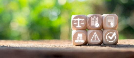 Wooden blocks with icons representing compliance, law, and regulation concepts on a natural...