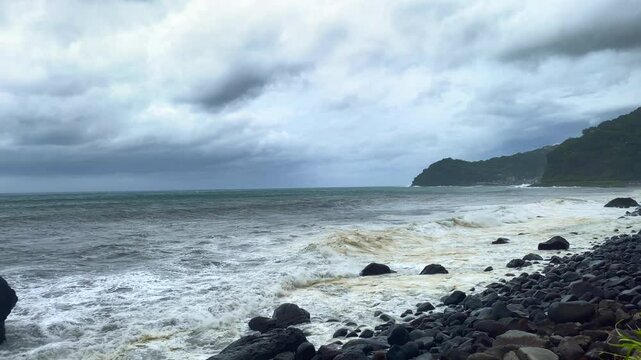 Captivating 4K60P footage of immense waves unleashed by a powerful typhoon. The gray, tumultuous sea showcases the raw and terrifying power of nature, with relentless waves crashing against the coastl