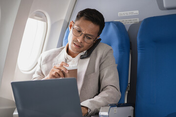 Tired businessman talking on the phone arguing work problems highlighting customer dissatisfaction while sitting in the airplane, Passengers near the window.