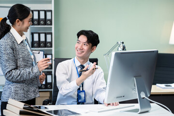 Business documents on office table with smart phone, tablet and laptop computer and graph with social network diagram and two colleagues discussing data in office.