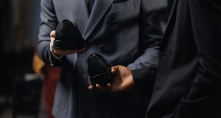 Man in suit hold leather footwear, top view. Male buy fashion shoes in store