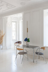 bright interior design of spacious living room with white walls and decorative unique historical moldings on ceiling stylish modern furniture in warm colors without people daylight through the windows