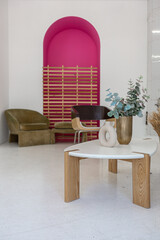 bright interior design of spacious living room with white walls and decorative unique historical moldings on ceiling stylish modern furniture in warm colors without people daylight through the windows