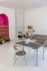 bright interior design of spacious living room with white walls and decorative unique historical moldings on ceiling stylish modern furniture in warm colors without people daylight through the windows