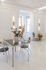 bright interior design of spacious living room with white walls and decorative unique historical moldings on ceiling stylish modern furniture in warm colors without people daylight through the windows