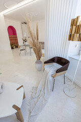 bright interior design of spacious living room with white walls and decorative unique historical moldings on ceiling stylish modern furniture in warm colors without people daylight through the windows