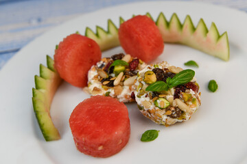 RECIPE OF SALAD OF FETA RINGS COATED WITH DRIED FRUIT, PISTACHE, NUTS AND PASTEQUE