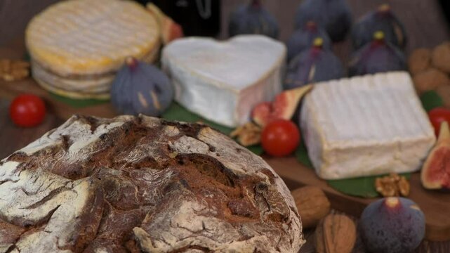 Selection of French cheeses from Normandy, AOP, Livarot, Neufchatel, Pont l'eveque, Pain de seigle, figs, walnuts, grapes, elderberry gelee. High quality 4k footage