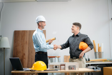 Engineer desk with object paper and tablet with blurry engineer teamwork hardworking to consults about their building project...