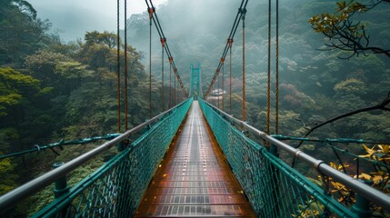 A suspended bridge beckons visitors to explore the foggy forest, surrounded by lush greenery and mountains