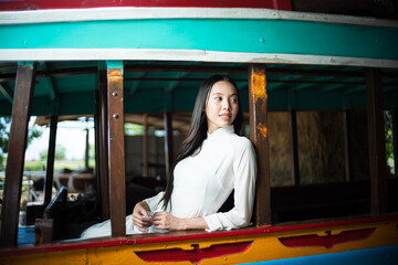 Young Vietnamese woman on a bus in the countryside. Ao dai is famous traditional costume for women in Vietnam.