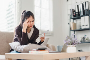 Close up of woman using calculator and holding receipts while managing finances at home.