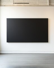 A large, empty black canvas mounted on a minimalist white wall in a contemporary art gallery, creating a stark contrast and inviting contemplation