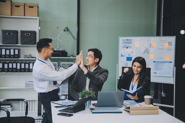 Group of colleagues engaging in a discussion during a business meeting in a conference room. Happy business people, men and women, collaborating and working towards their shared goals.