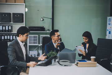 Group of colleagues engaging in a discussion during a business meeting in a conference room. Happy business people, men and women, collaborating and working towards their shared goals.