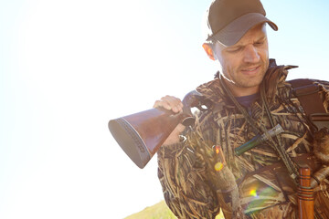 Man, hunter and rifle in camouflage for sport, activity and trophy as wildlife enthusiast. Male...