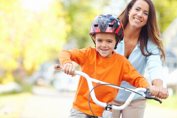 Bike, learning and portrait of boy with mother outdoor on street of neighborhood for child development. Happy, love or smile with single parent woman teaching son how to ride bicycle in summer