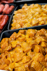 seasoned raw chicken for sale in a butcher shop