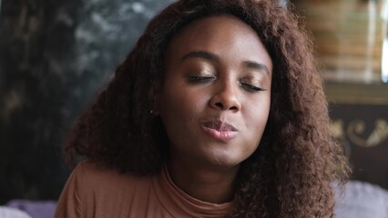 Such delicious tasty filling food. Close-up of a curly-haired beautiful woman tasting food in a new restaurant.