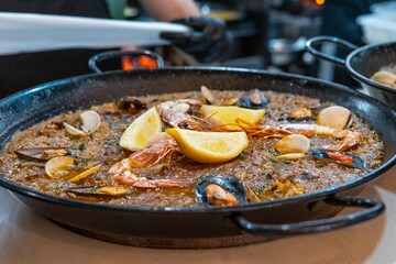 typical Spanish seafood paella, made with rice, seafood, pepper, saffron, mussels, prawns, lemon and snails