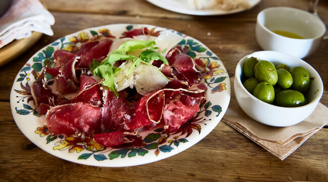 Cecina. A plate with green olives and another with cecina and cheese slices. Cecina is very typical of Le&oacute;n and Castile, in Spain.