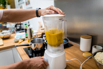 Chef at the kitchen preparing pumpkin porridge with tofu and vegetables