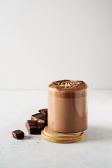 Protein chocolate cocktail drink in glass with powder and scoop