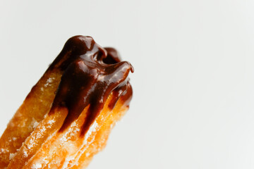 churros dipped on chocolate with sugar powder sprinkles