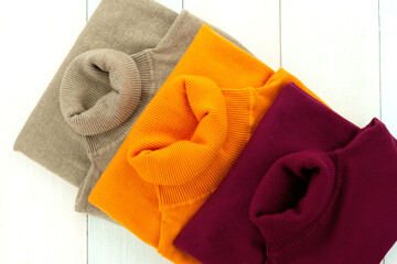 Three multi-colored turtlenecks for women. Turtleneck clothes for autumn and winter. Warm knitwear.