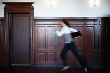 Business, person and running in building with motion blur, urgency or legal document for case. Lawyer, fast or rush to courtroom with evidence, information or late for hearing with folder for justice