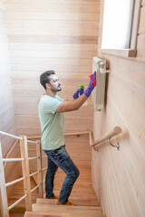 Cheerful man cleans radiator and prepares for harsh winter and heating season	