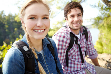 Fototapeta premium Portrait, break or happy couple hiking by lake for travel, outdoor adventure or journey in nature with smile. Relax, resting or people in forest on holiday vacation, fun trip or river to explore park