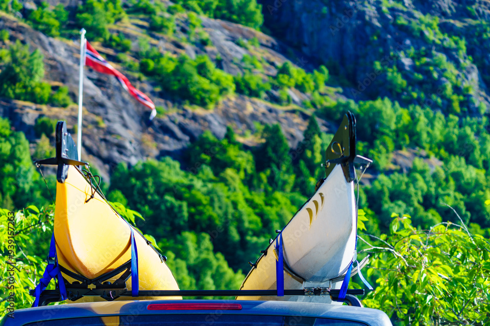 Wall mural car with canoe on top roof in mountains