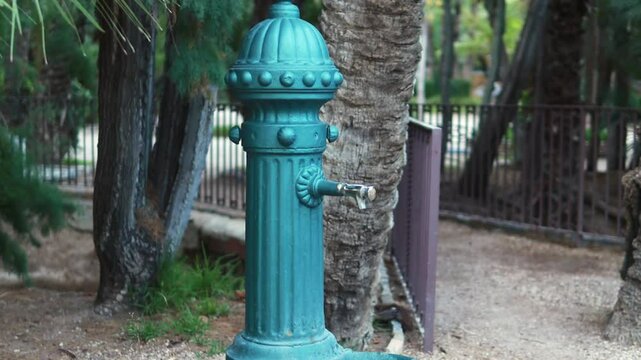 antique metal fountain in park,  tranquility of nature and the elegance of classic design, slow motion