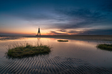 Sonnenaufgang im Cuxhavener Wattenmeer mit der Kugelbake im Hintergrund