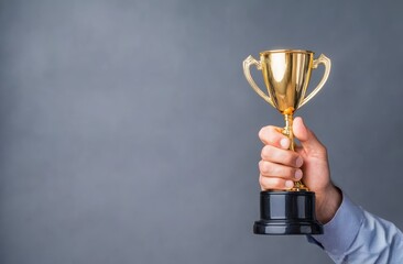 A businessman holds a gold cup symbolizing success and achievements in corporate development