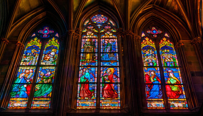 Fototapeta premium Vivid stained glass window depicting an ancient mythological scene, casting colorful light inside a dimly lit cathedral.