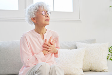 動悸がするシニア女性　リビングルーム