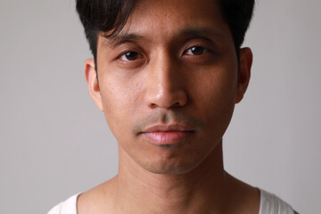 Obraz premium Close-up portrait of asian young man, posing over white wall.